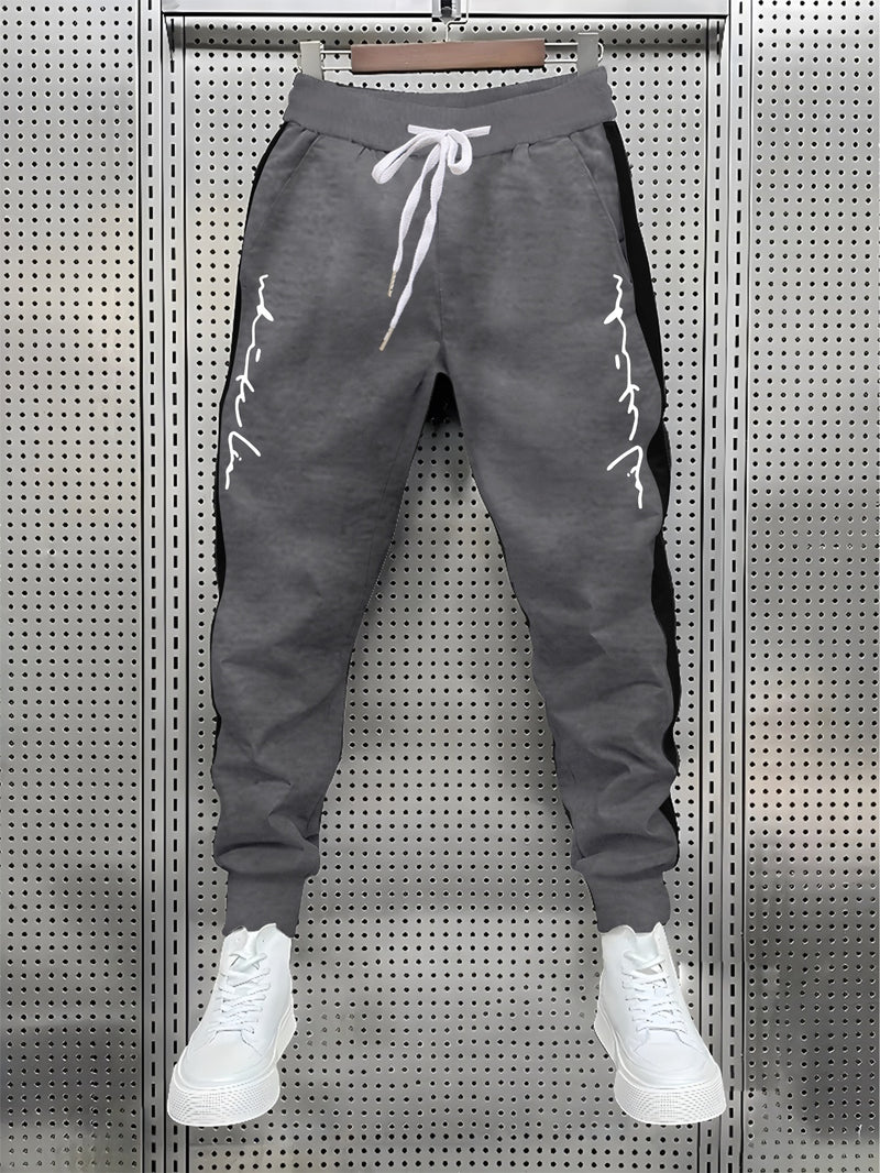 Men's Color Blocked Drawstring Sports Pants with Eye-catching Print Design.